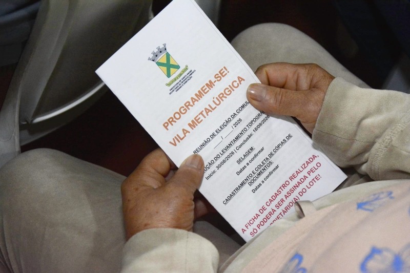 Morador segura folheto informativo sobre regularização fundiária da Vila Metalúrgica em Santo André