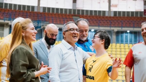 Prefeito Marcelo Lima sorrindo ao lado de atleta com síndrome de Down durante lançamento da Escola de Futsal adaptada em ginásio de São Bernardo