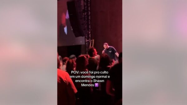 Multidão durante culto em igreja de São Caetano do Sul com pessoa no palco ao microfone
