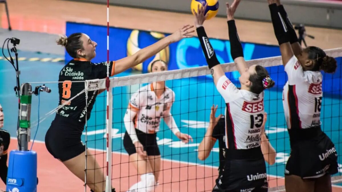 Jogadoras de vôlei disputam bola na rede durante partida de clubes femininos