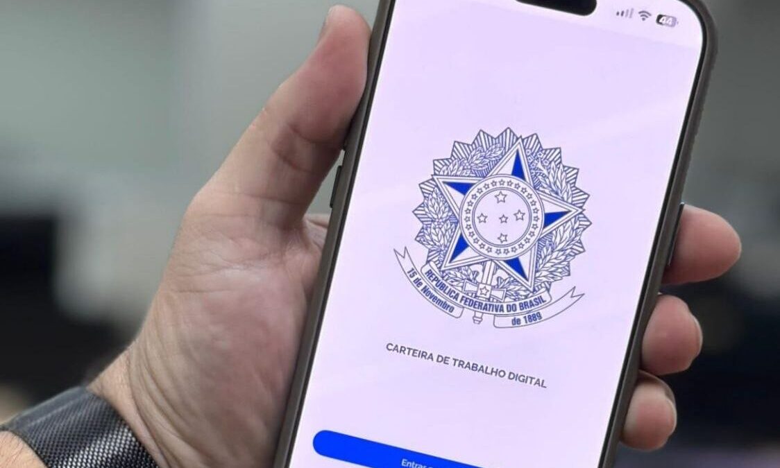 Mão segurando celular com aplicativo da Carteira de Trabalho Digital aberto