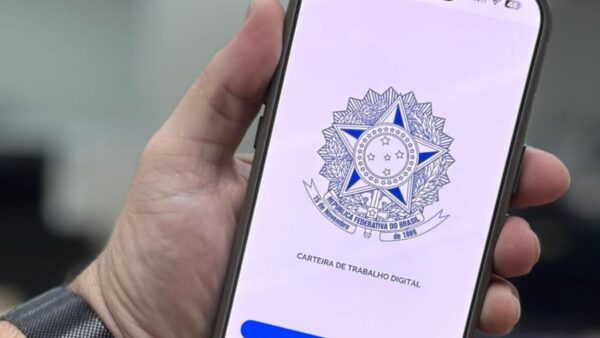 Mão segurando celular com aplicativo da Carteira de Trabalho Digital aberto
