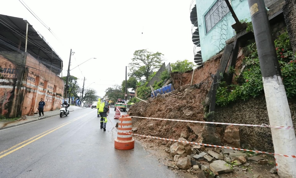 Rua interditada com cones e destroços após desabamento de muro provocado por chuva em Diadema