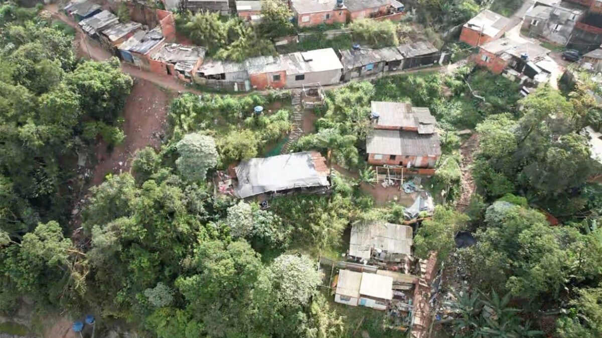Vista aérea de área de encosta com casas entre a vegetação no Jardim Santo André