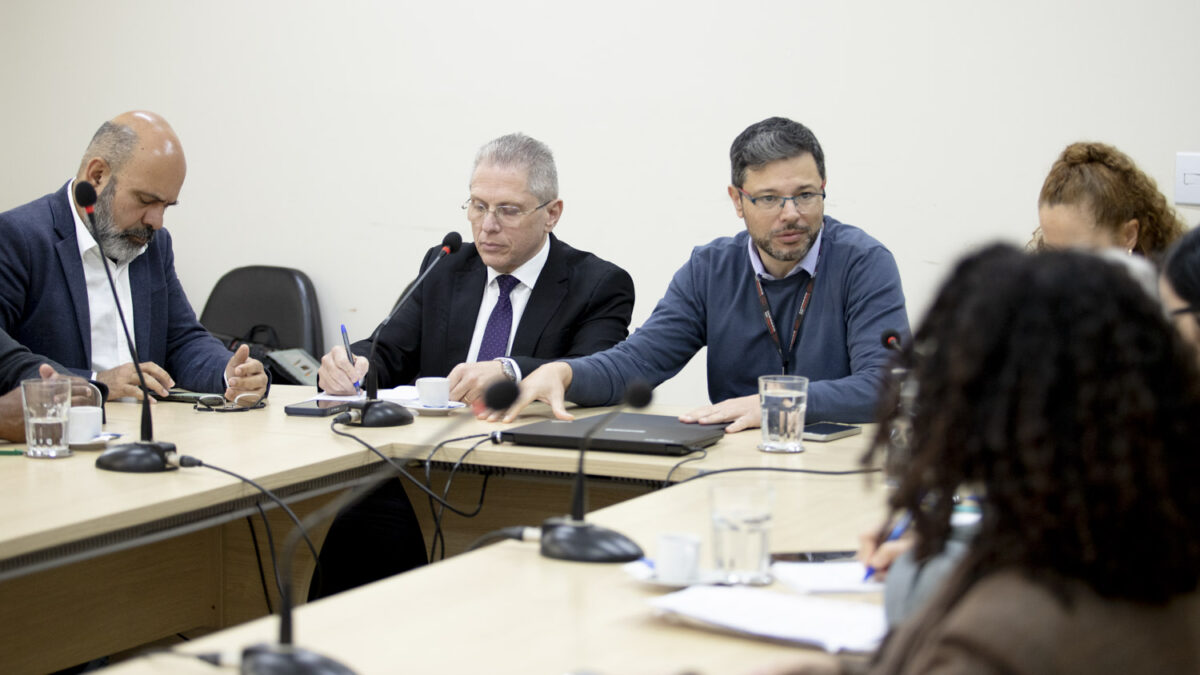 Secretário de Saúde de São Bernardo do Campo reunido com técnicos à mesa durante reunião sobre o futuro AME