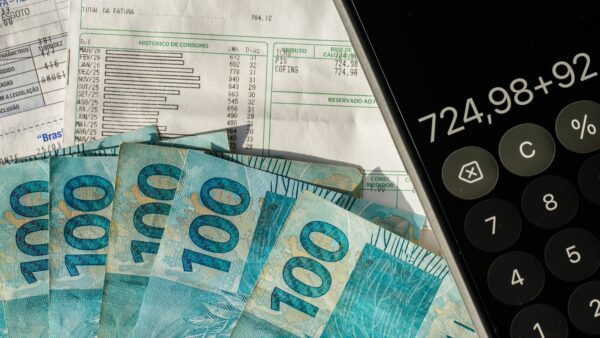 Notas de R$ 100, contas de consumo e calculadora