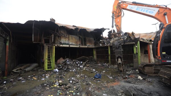 Máquina de demolição trabalha em meio aos escombros do pavilhão do Ceagesp atingido por incêndio, em São Paulo (07/10/2026). Foto: Paulo Pinto/Agência Brasil
