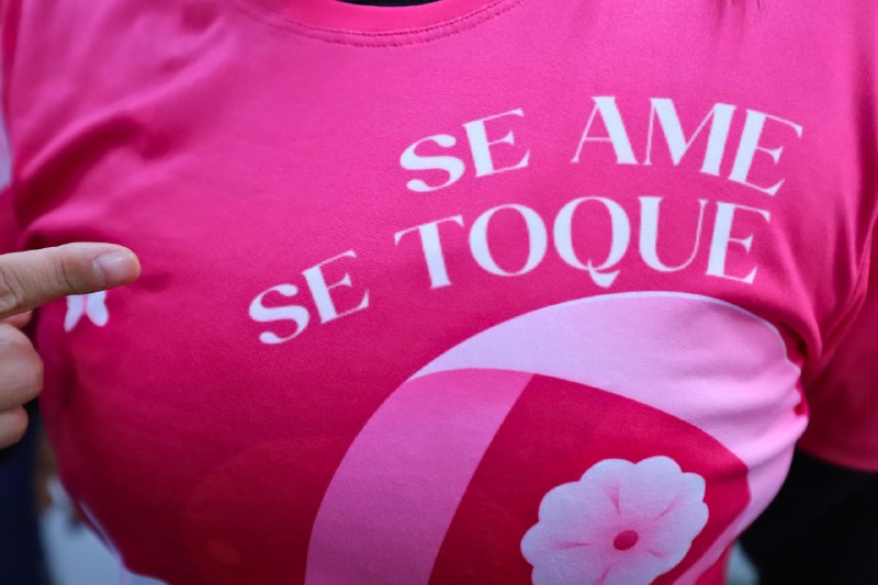 Close de camiseta rosa com a frase Se ame, se toque, da campanha Outubro Rosa em Diadema