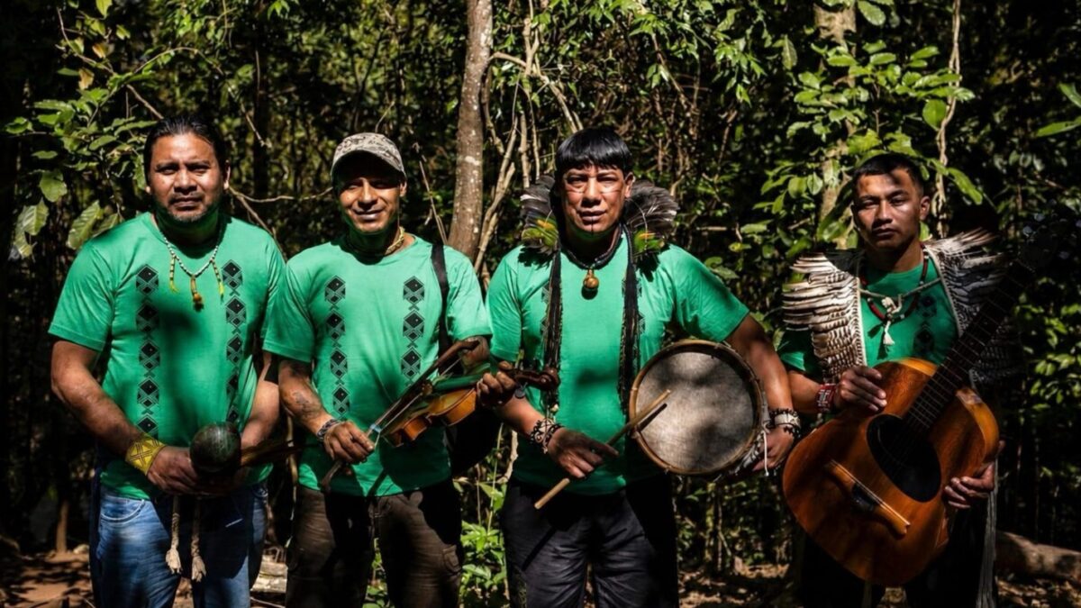 Integrantes do Coral Purahei Marangatu, dos povos Guarani Mbya e Nhandeva, com instrumentos na mata