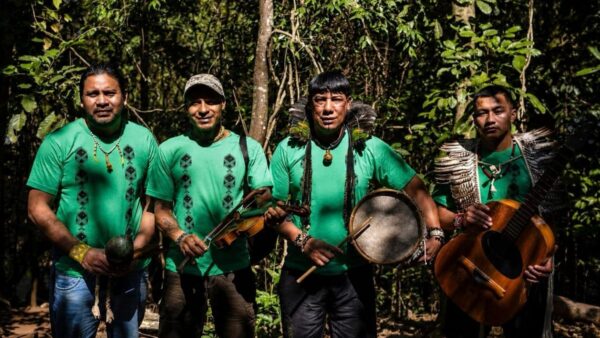 Integrantes do Coral Purahei Marangatu, dos povos Guarani Mbya e Nhandeva, com instrumentos na mata