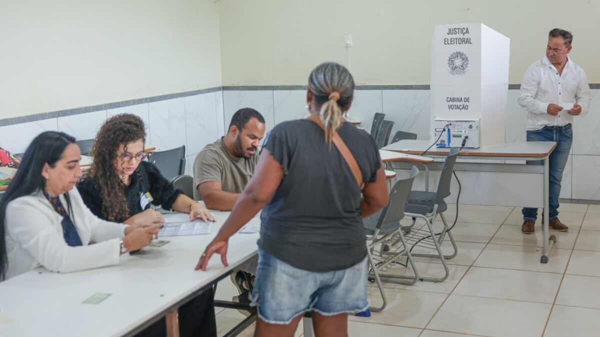 Mesários atendem eleitora em seção eleitoral de Brasília no primeiro turno, em 4 de outubro de 2026
