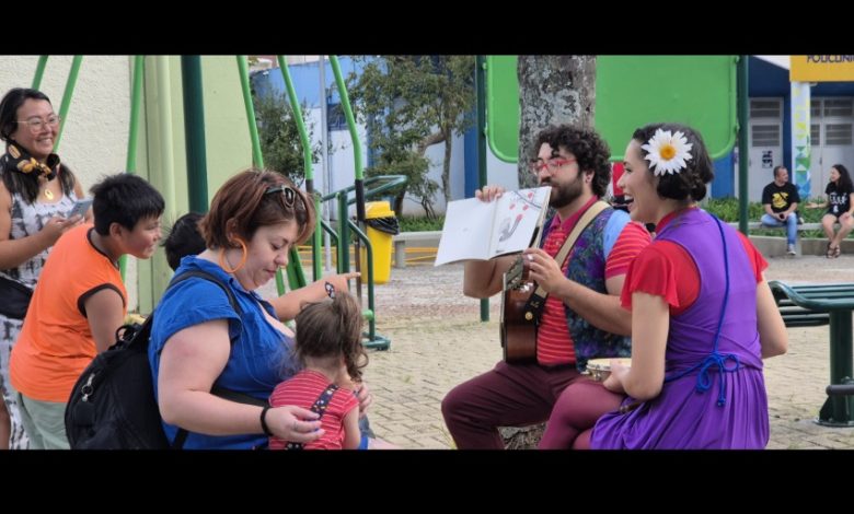 Artistas contam histórias com violão e livro para crianças e famílias em área de lazer